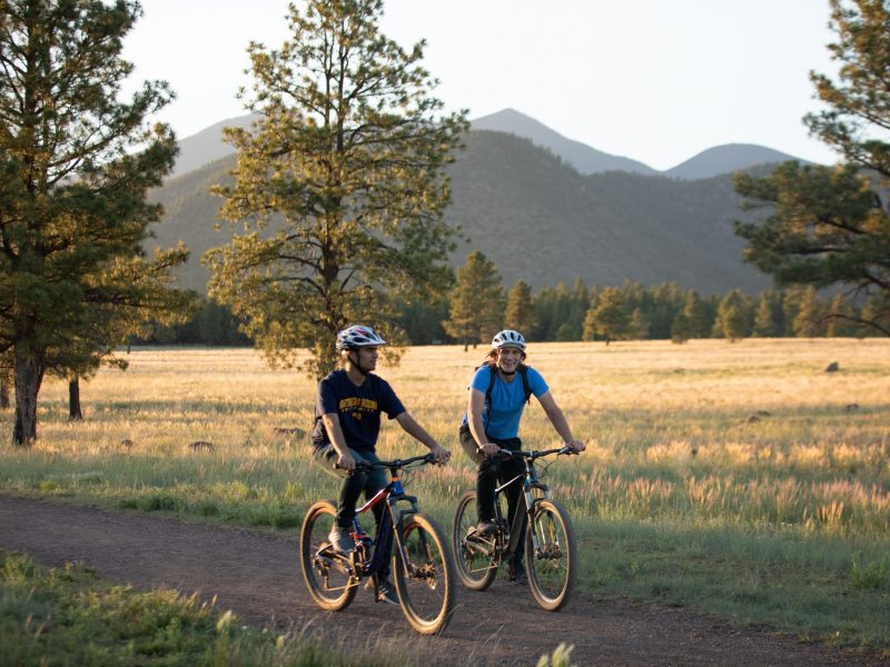 Two N A U students riding bicycles.