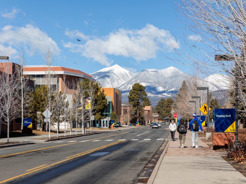 Students walking on the NAU campus with the San Francisco peaks in the background.