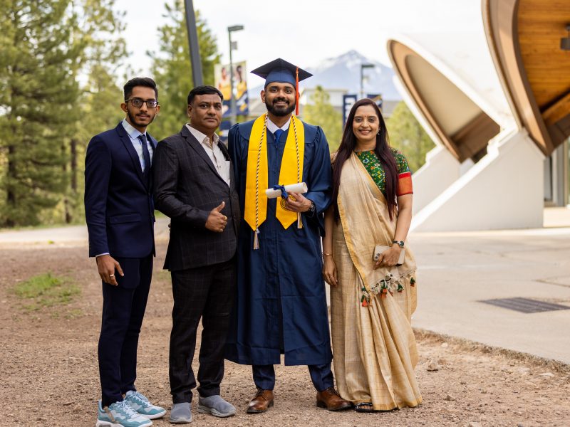 An N A U student at graduation ceremony with his family.