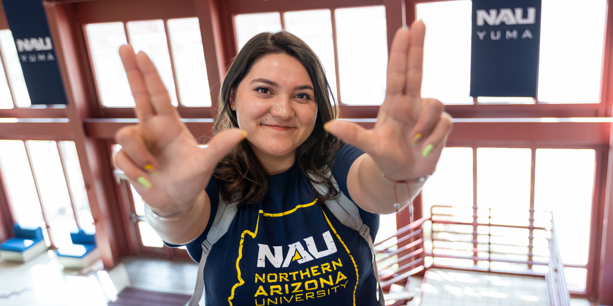 A student make the NAU lumberjack hand signal.