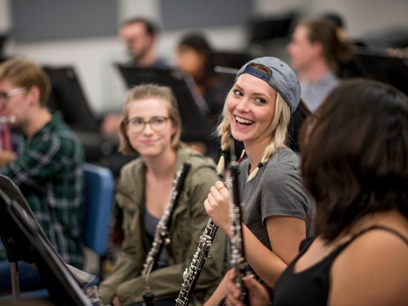 Flute students laughing and looking at eachother.