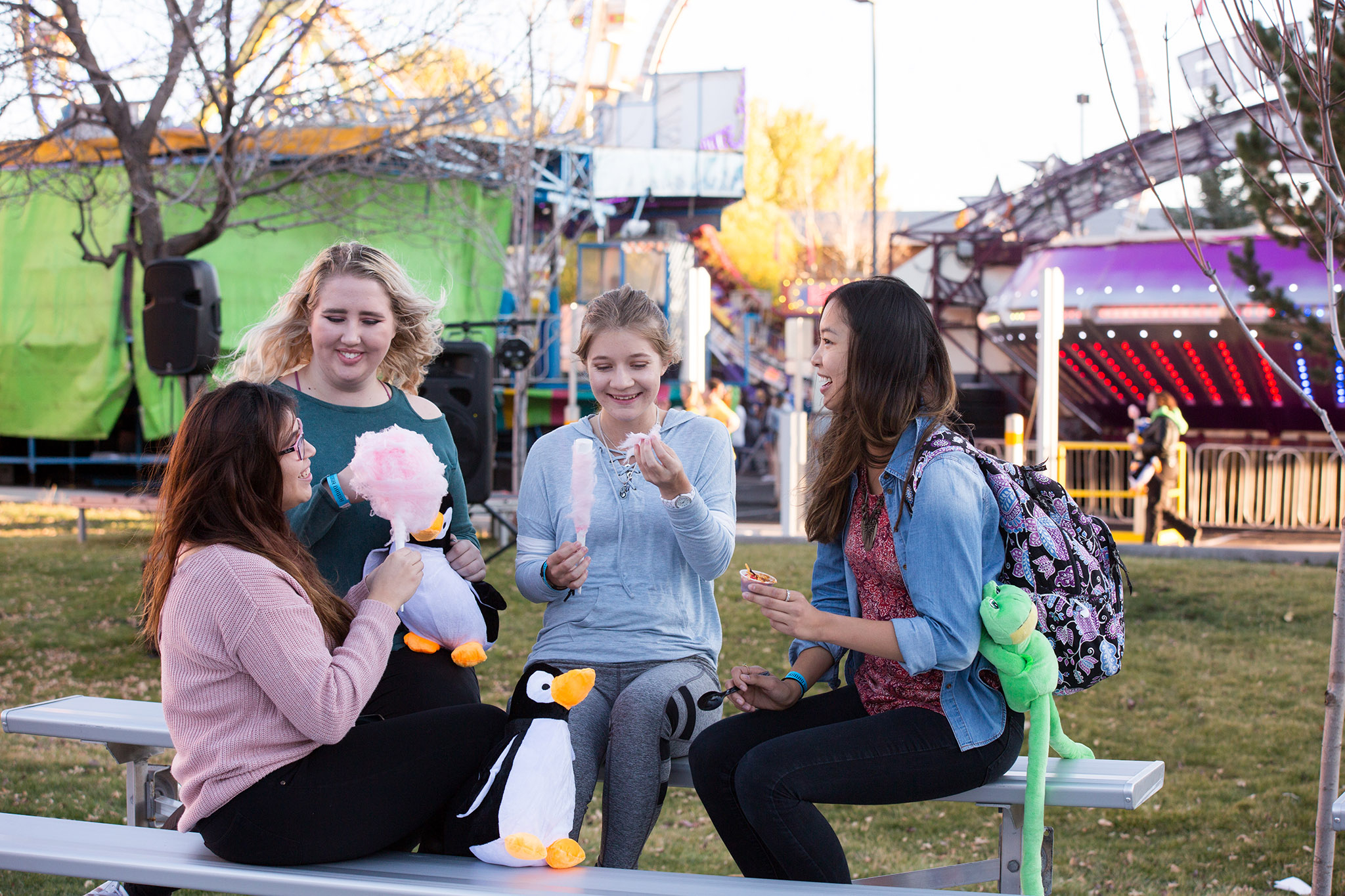 Students eating cotton candy on bench.