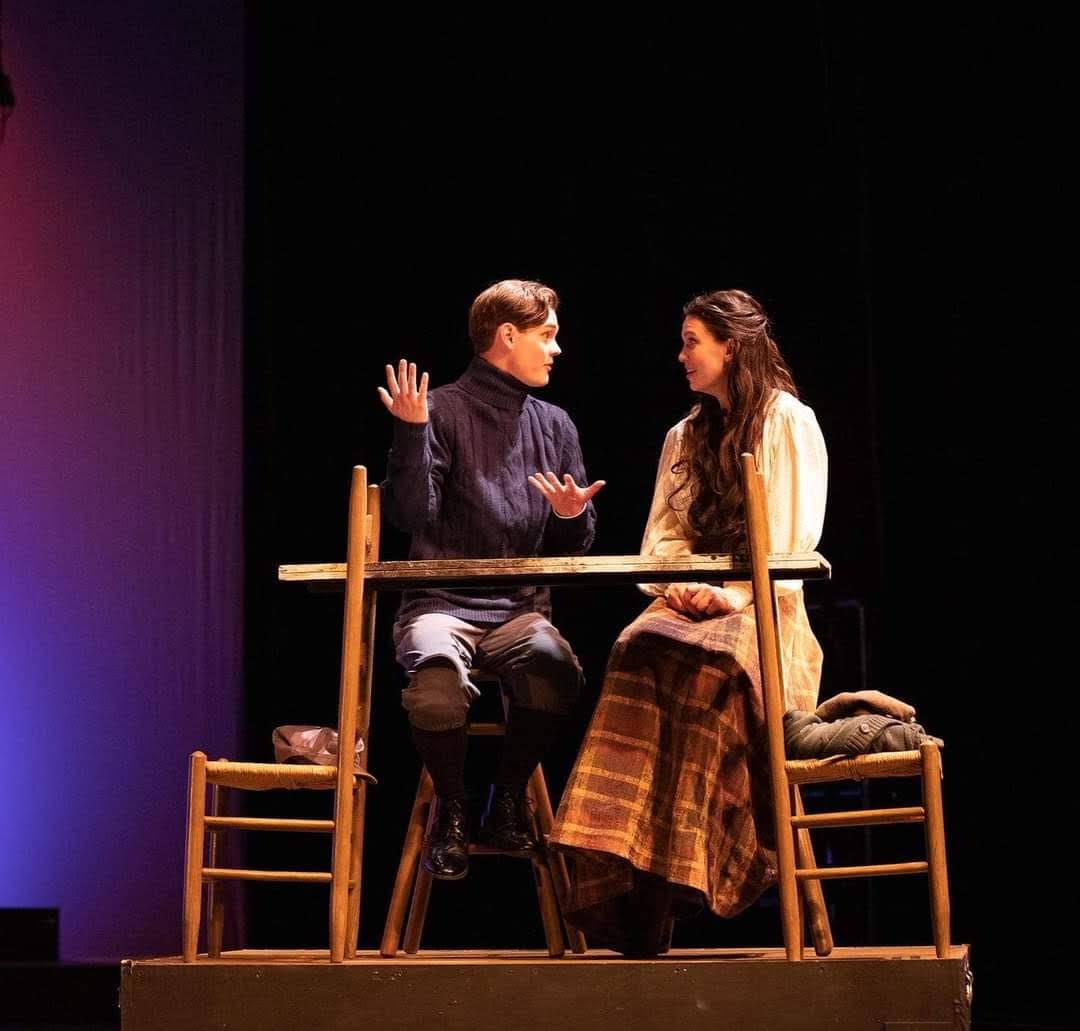 An actor and an actress talking on stage.