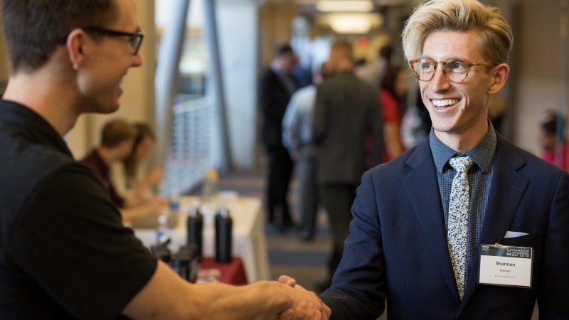 Two people in professional attire shaking hands.