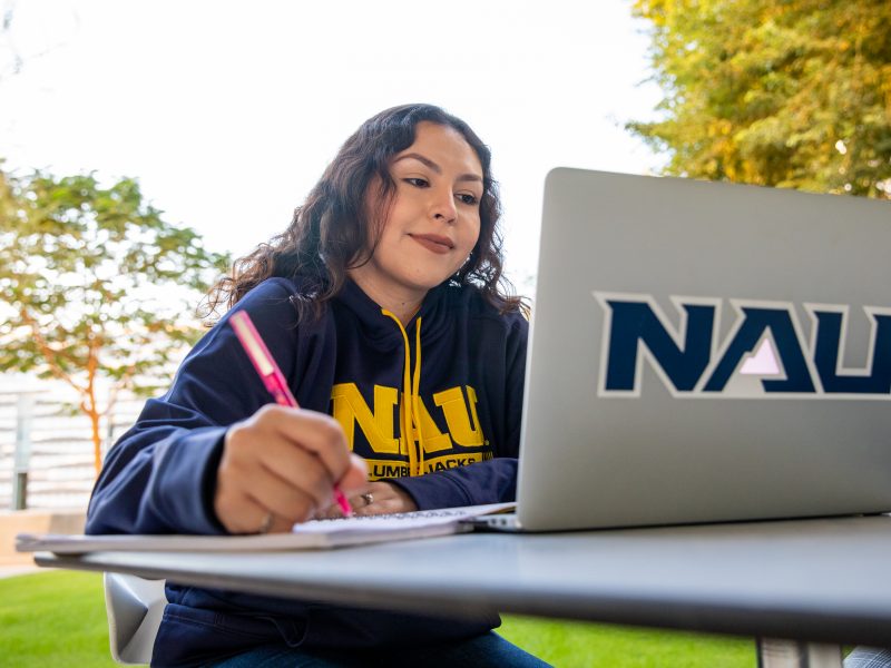 Student on laptop outdoors.