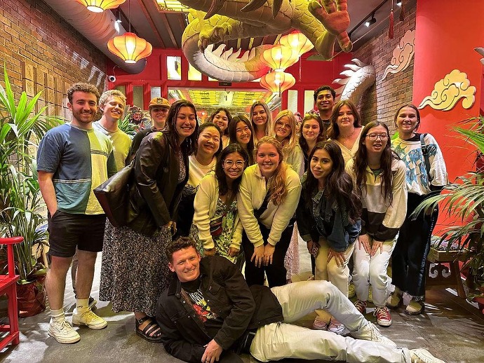 Group of students in Chinese restaurant in Spain under a dragon.