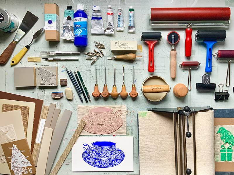 Painting and sculpting tools laid out and organized on a table.