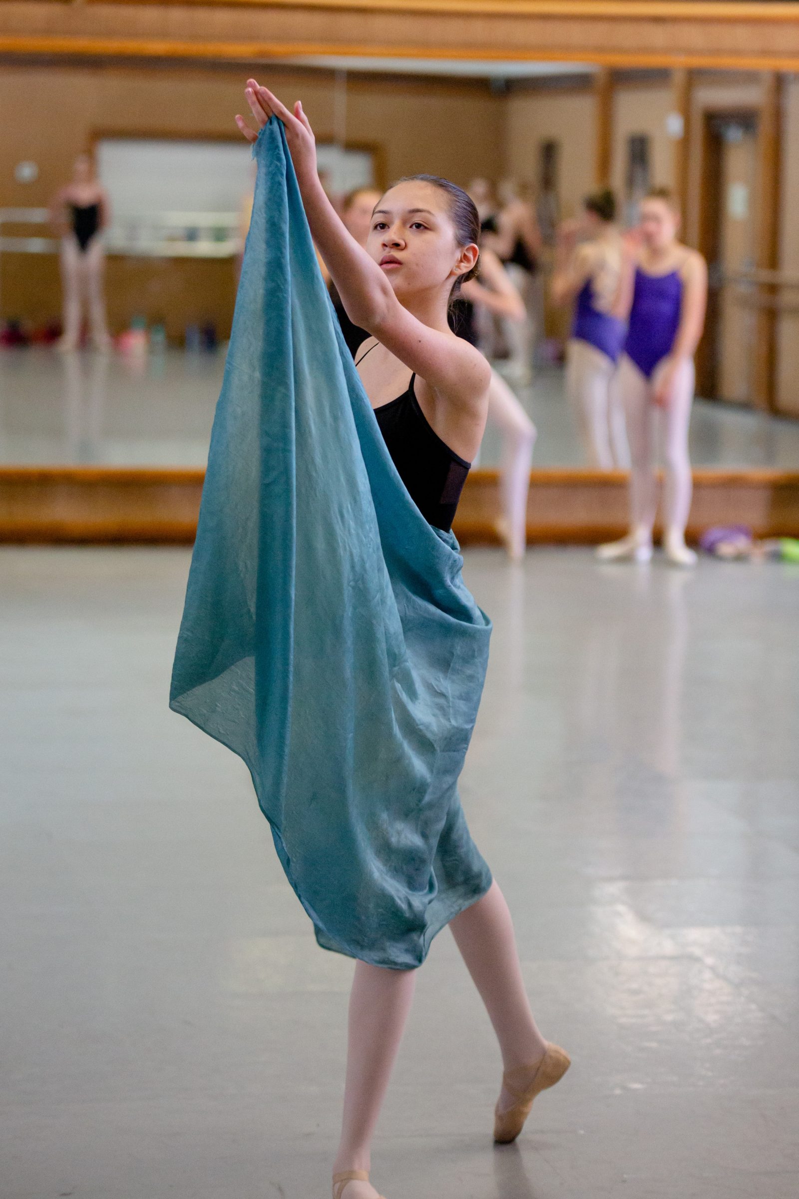 Ballet student holding up the tip of her skirt as part of a rehearsal.