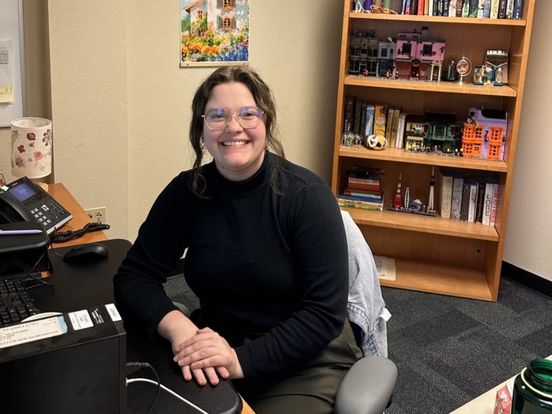 Hannah Riddell is sitting in her office and smiling.