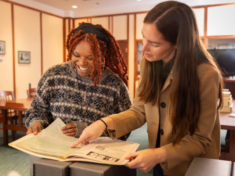 A student and professor looking at a history file.