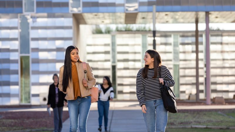 Dos estudiantes caminan juntos en el campus de NAU-Yuma.