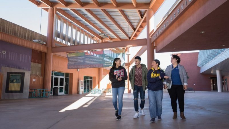 Un grupo de estudiantes caminan juntos mientras platican en el campus de NAU-Yuma.
