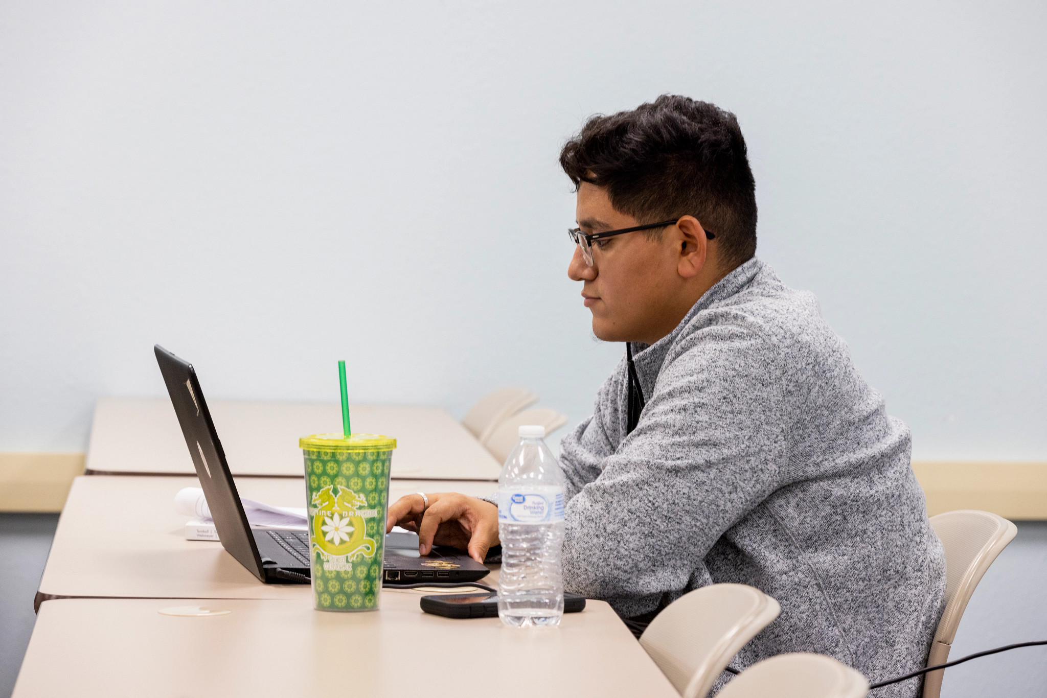 Un estudiante de NAU se sienta en un escritorio con una computadora portátil.