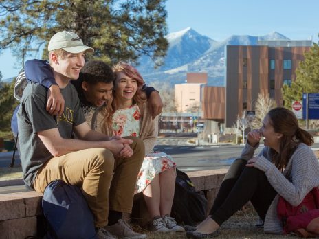 Candid photo of four friends on NAU campus.