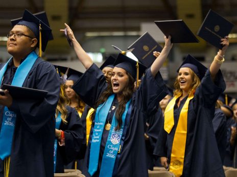 Group of graduates celebrating with their diplomas.