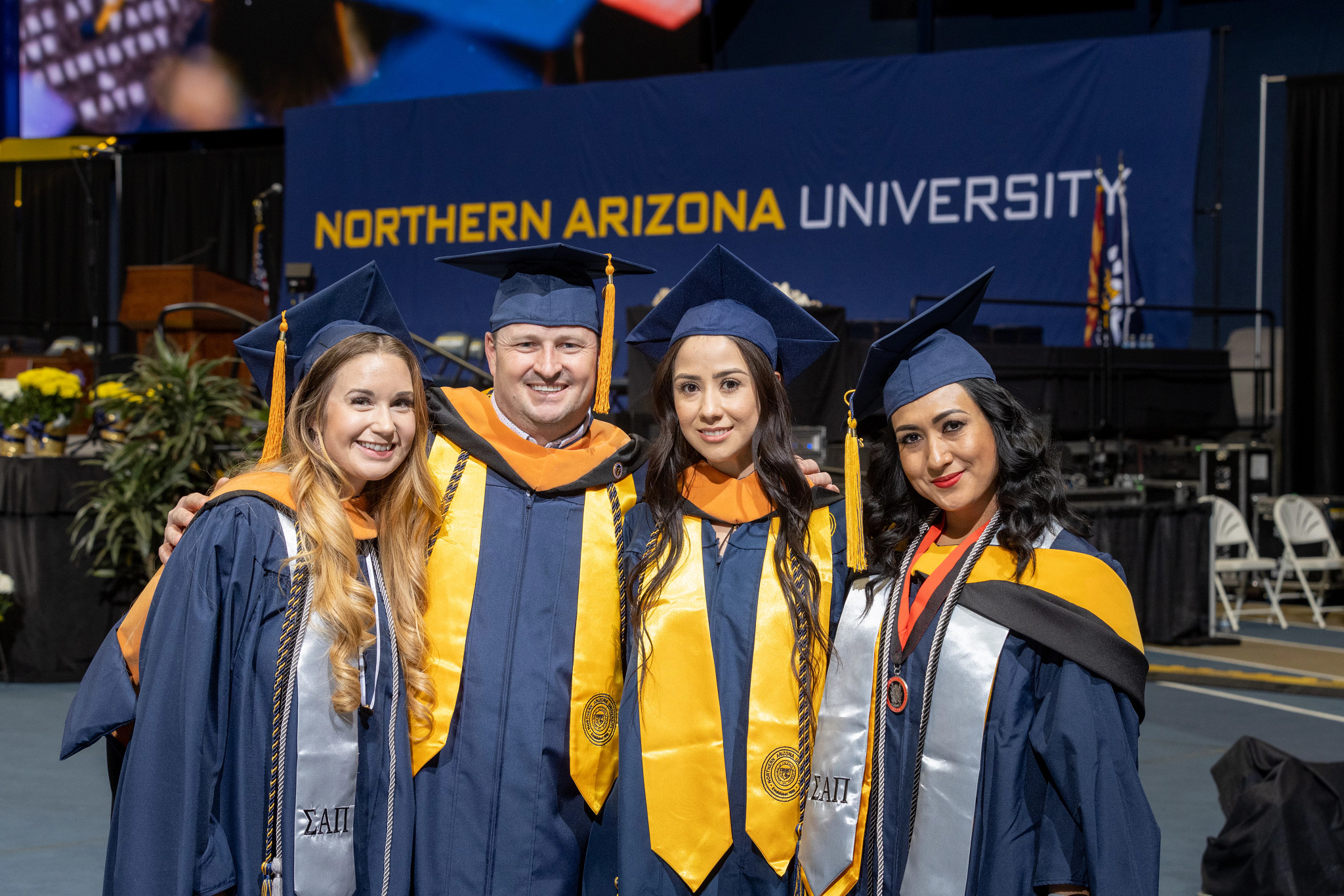 Four new graduates smiling.