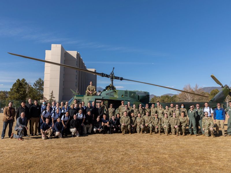 ROTC posing in front of helicopter. Picture is a button that directs to nau.edu/commencement/special-events/