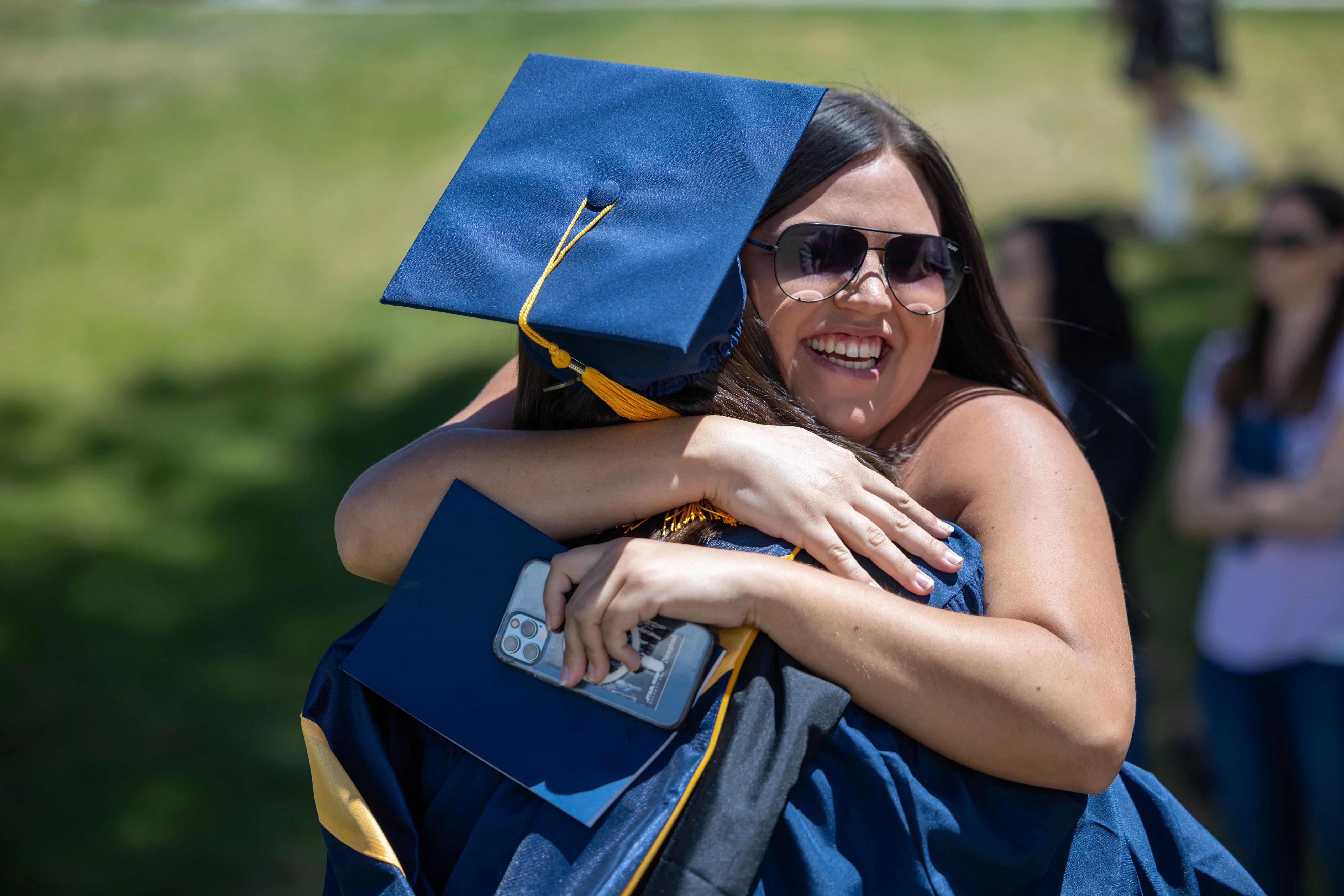 An NAU student hugs a family member outside after commencement is over