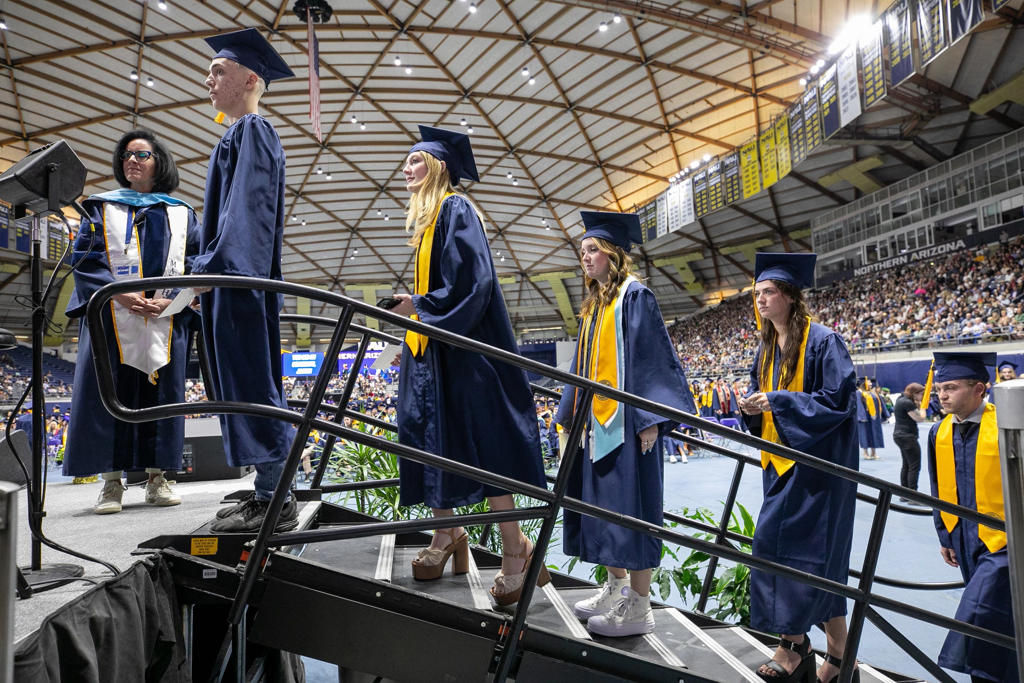 NAU students at commencement preparing to walk across the stage to receive their diplomas