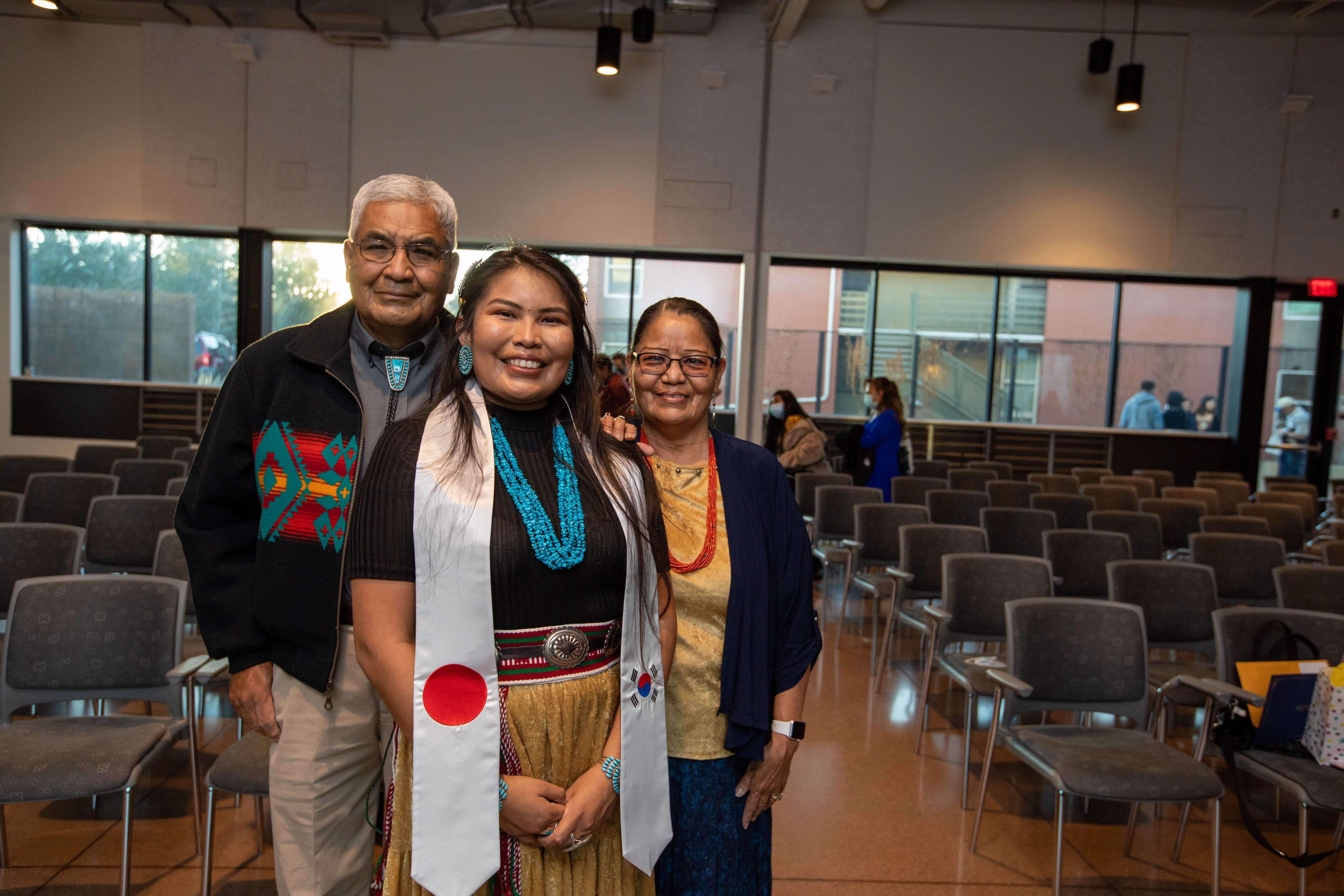 A female Native American NAU student poses for photo with her family