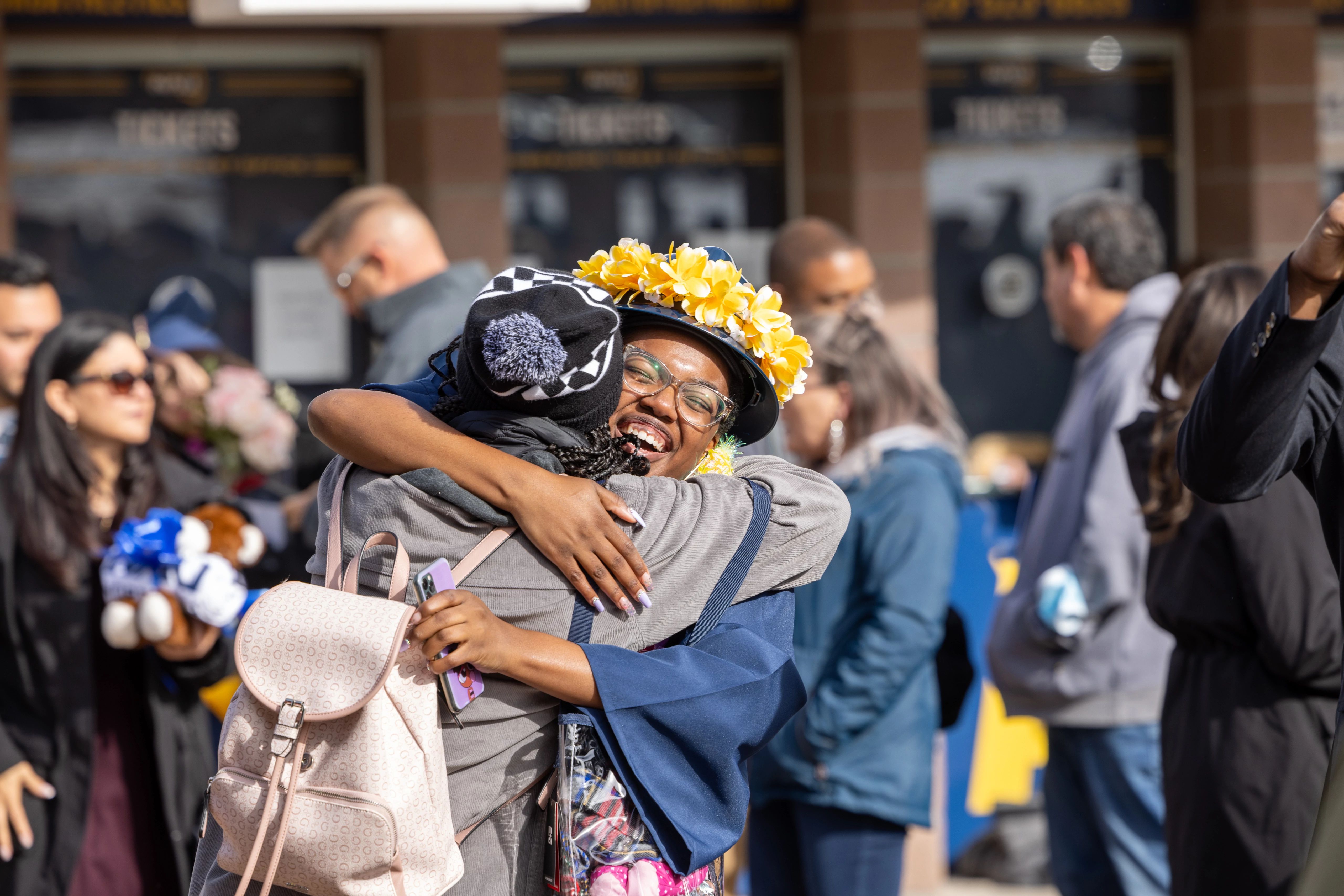 A guest hugs an NAU graduate outside after the ceremony