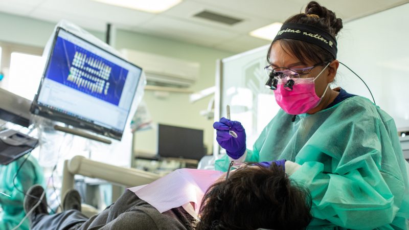 Dental Hygienist working with a patient.