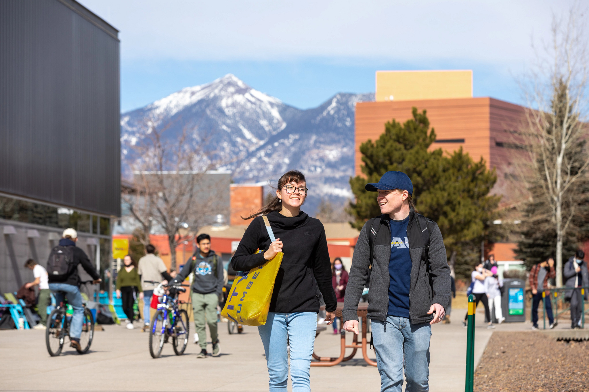 Students walking through campus grounds with mountains in the background.