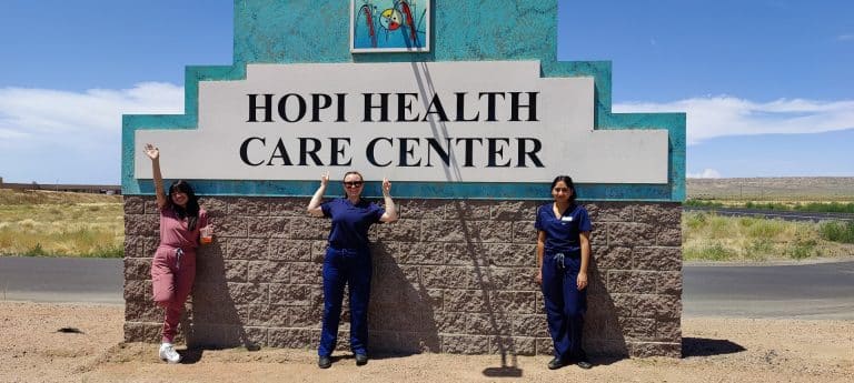 Students stand in front of the Hopi Health Care Center sign