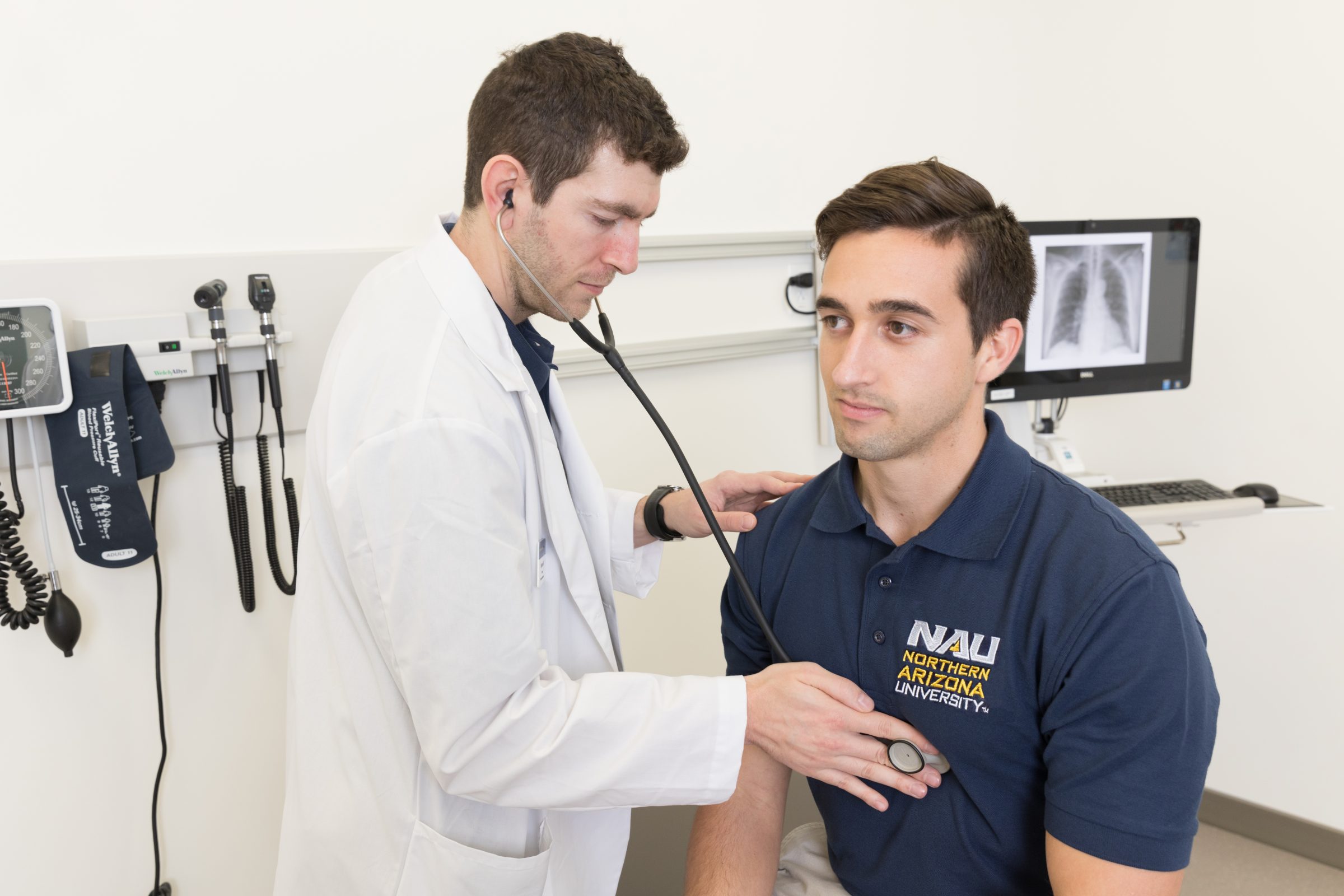 A professor from the Northern Arizona University Physician Assistant Program demonstrating listening to chest sounds.