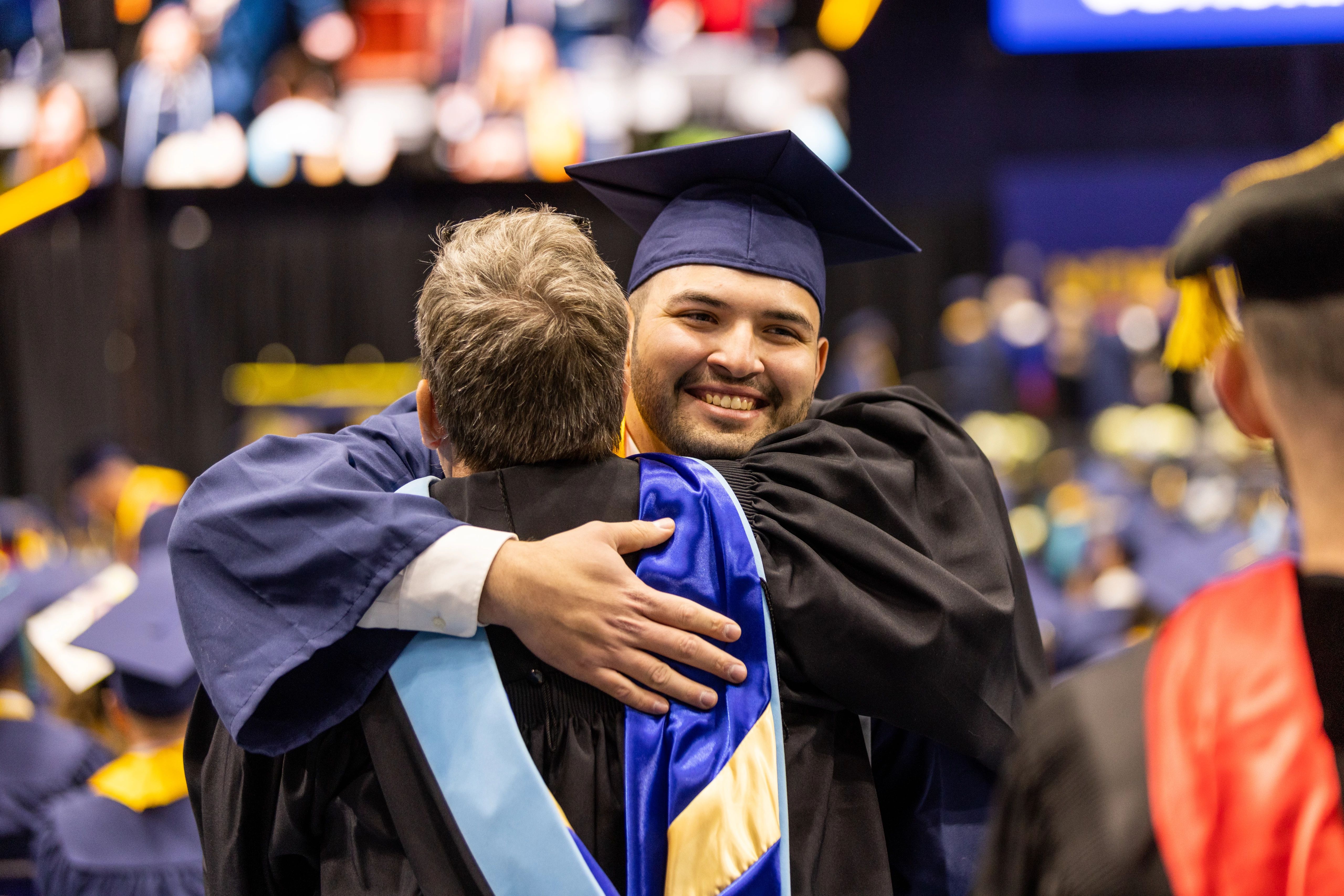 Graduate hugging faculty.