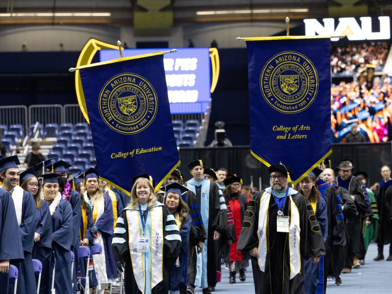 Faculty holding banners during commencement.