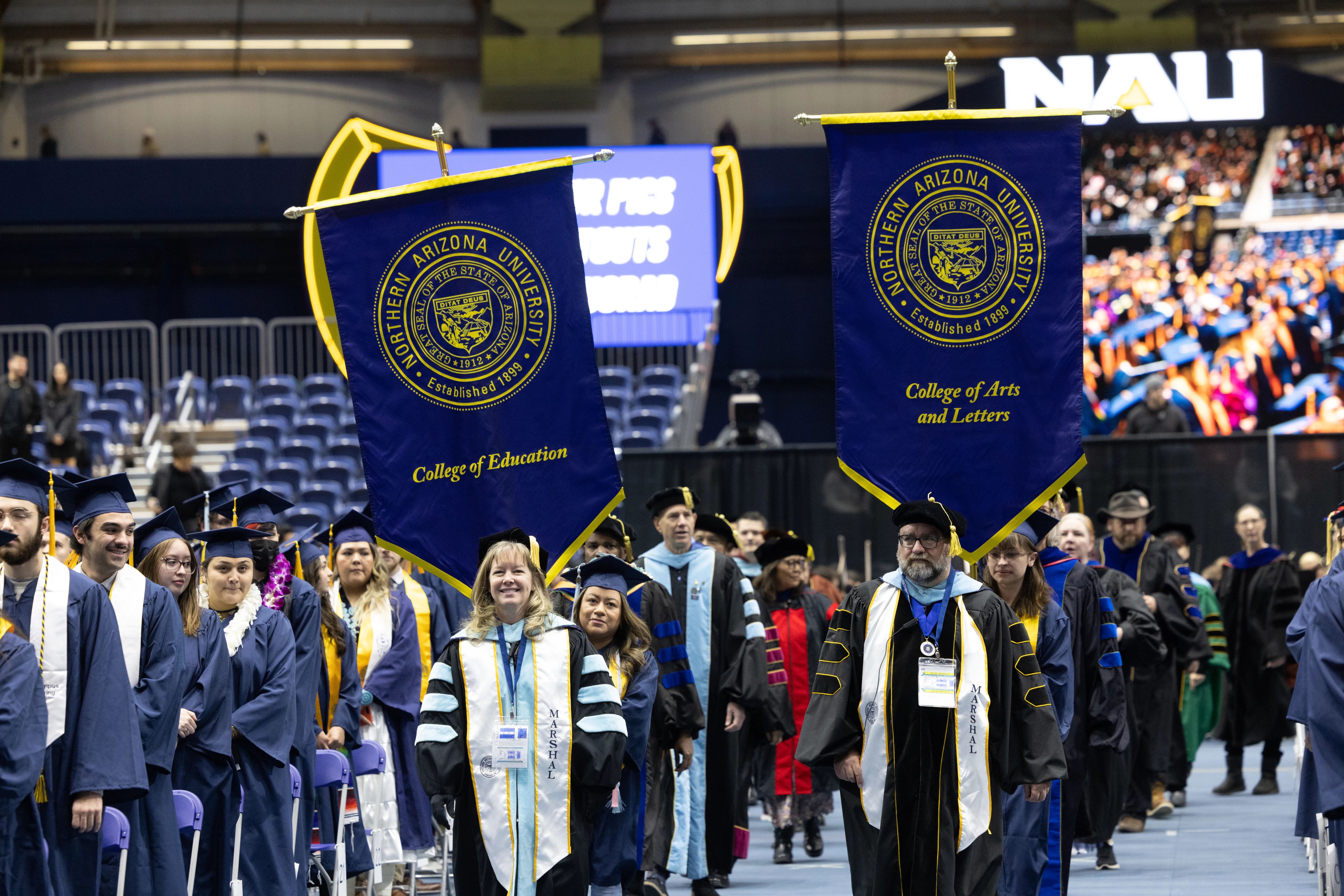 Faculty holding banners during commencement.
