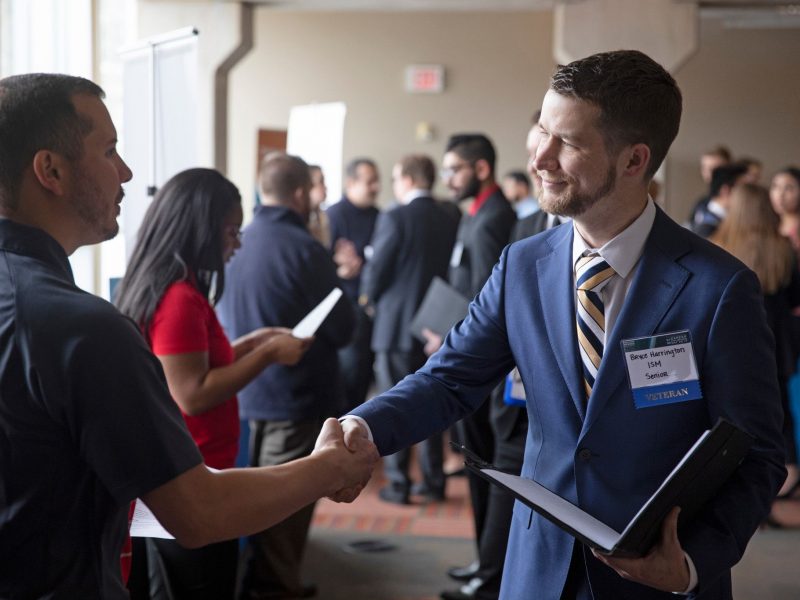 Student and recruiter shaking hands.