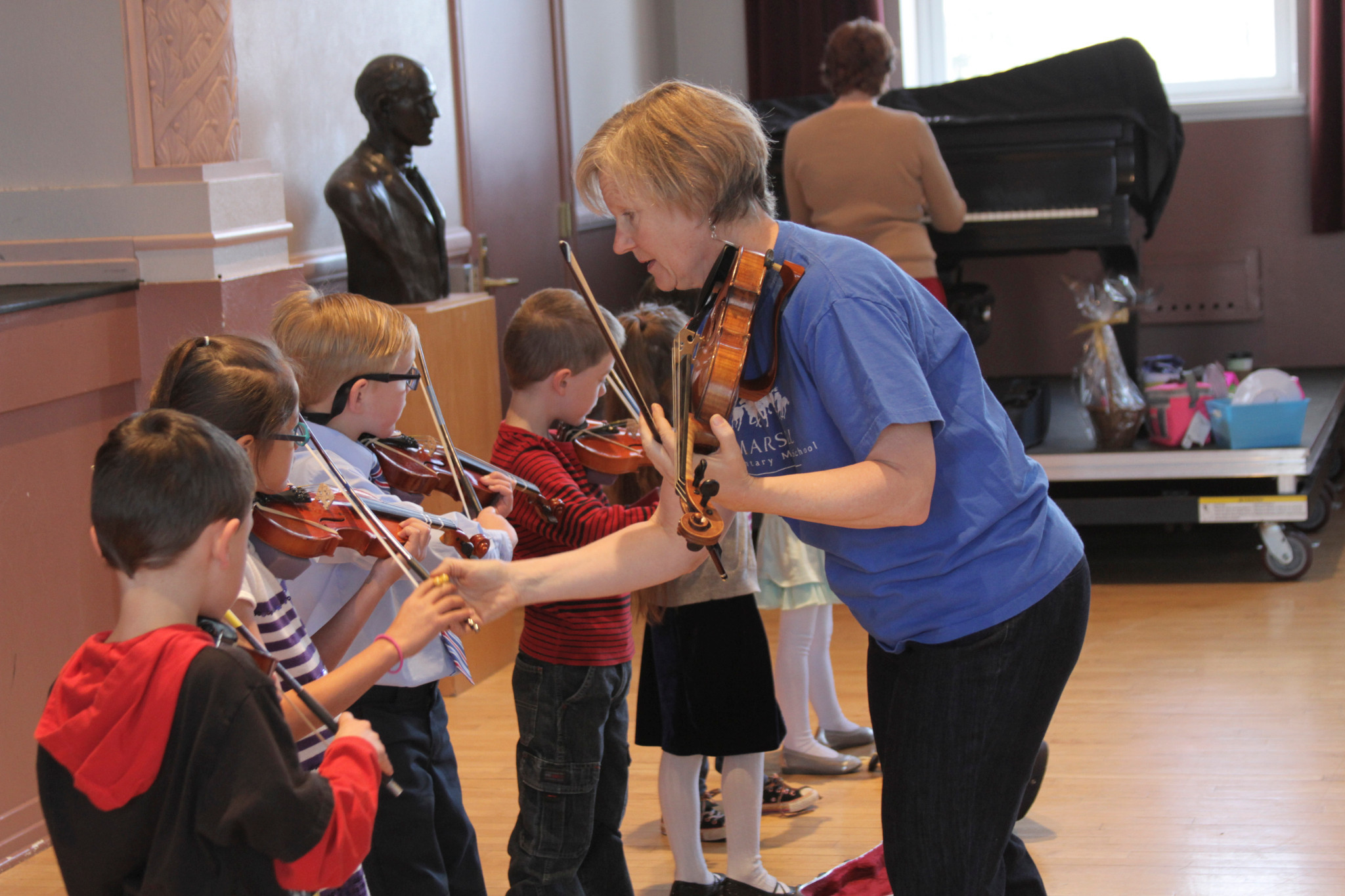 Student teacher helps with violin lessons.