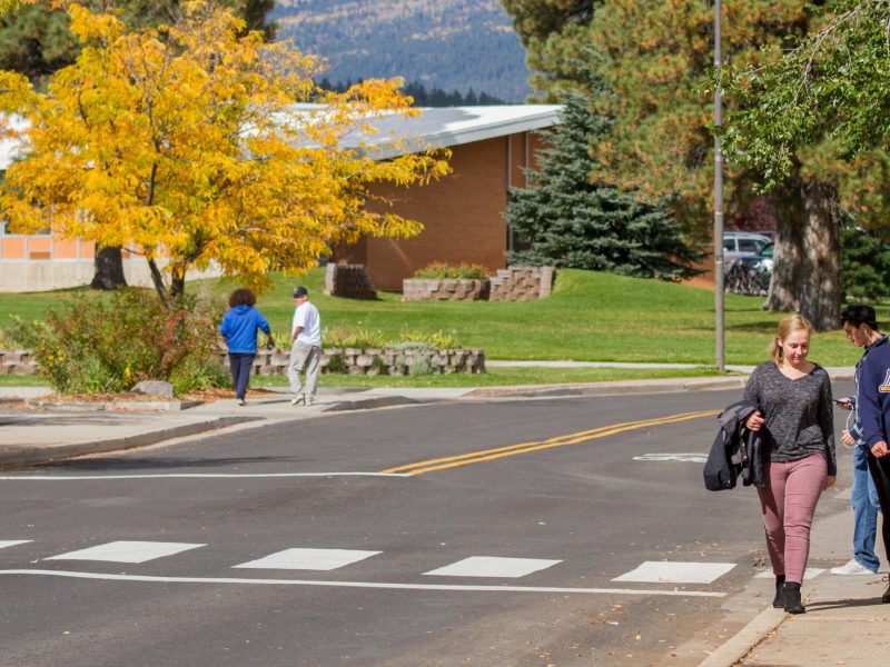 Three students walking on campus together.