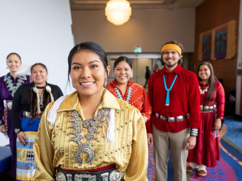 Indigenous students line up during convocation while exhibiting attire from their respective communities.