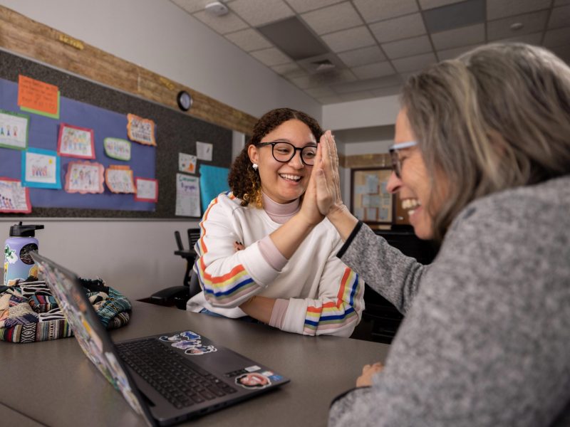 An image of N A U College of Education student Jazmyn Gardner high fiving a staff member.