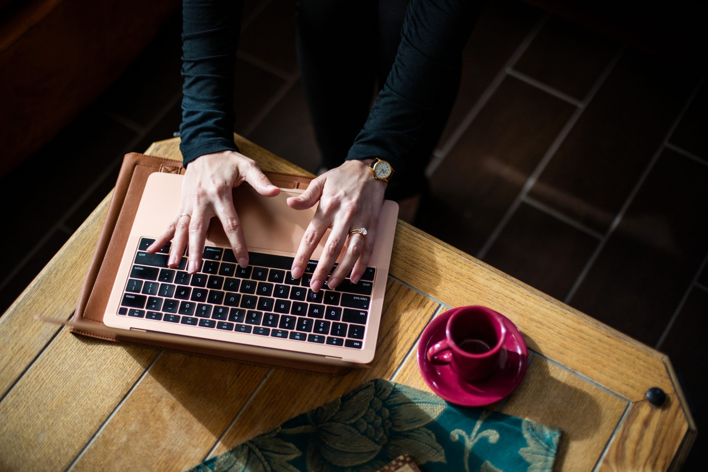 A student working on their laptop from home with a coffee cup on the table.