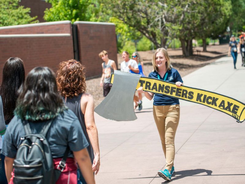 A staff worker walks with a Transfers Kick Axe sign.