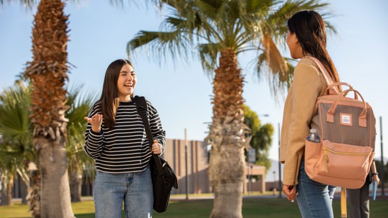 A photo of two students talking outside Yuma campus.