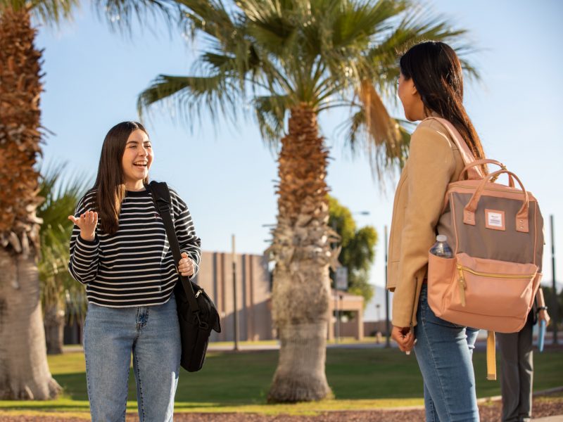 A photo of two students talking outside Yuma campus.