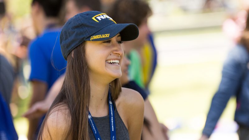 A photo of a new student smiling and wearing NAU gear.