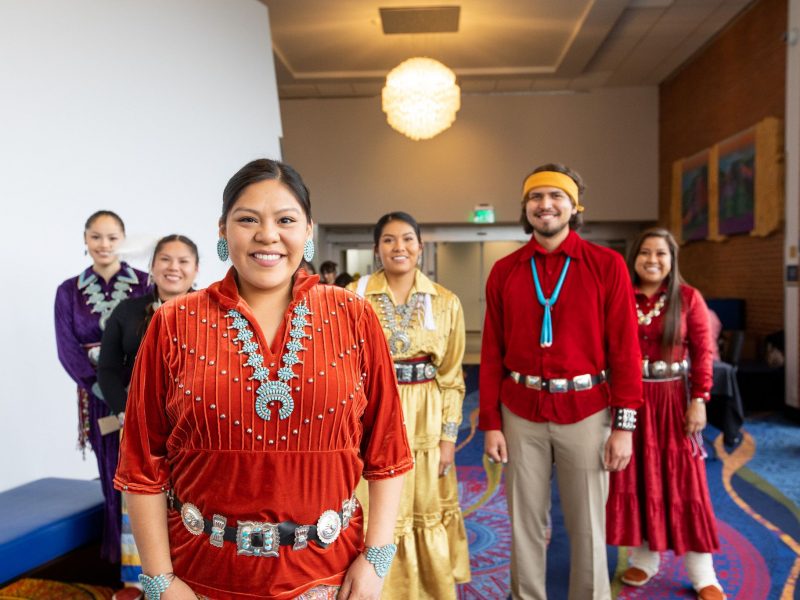 Students from Indigenous Convocation are standing together and posing for the camera.