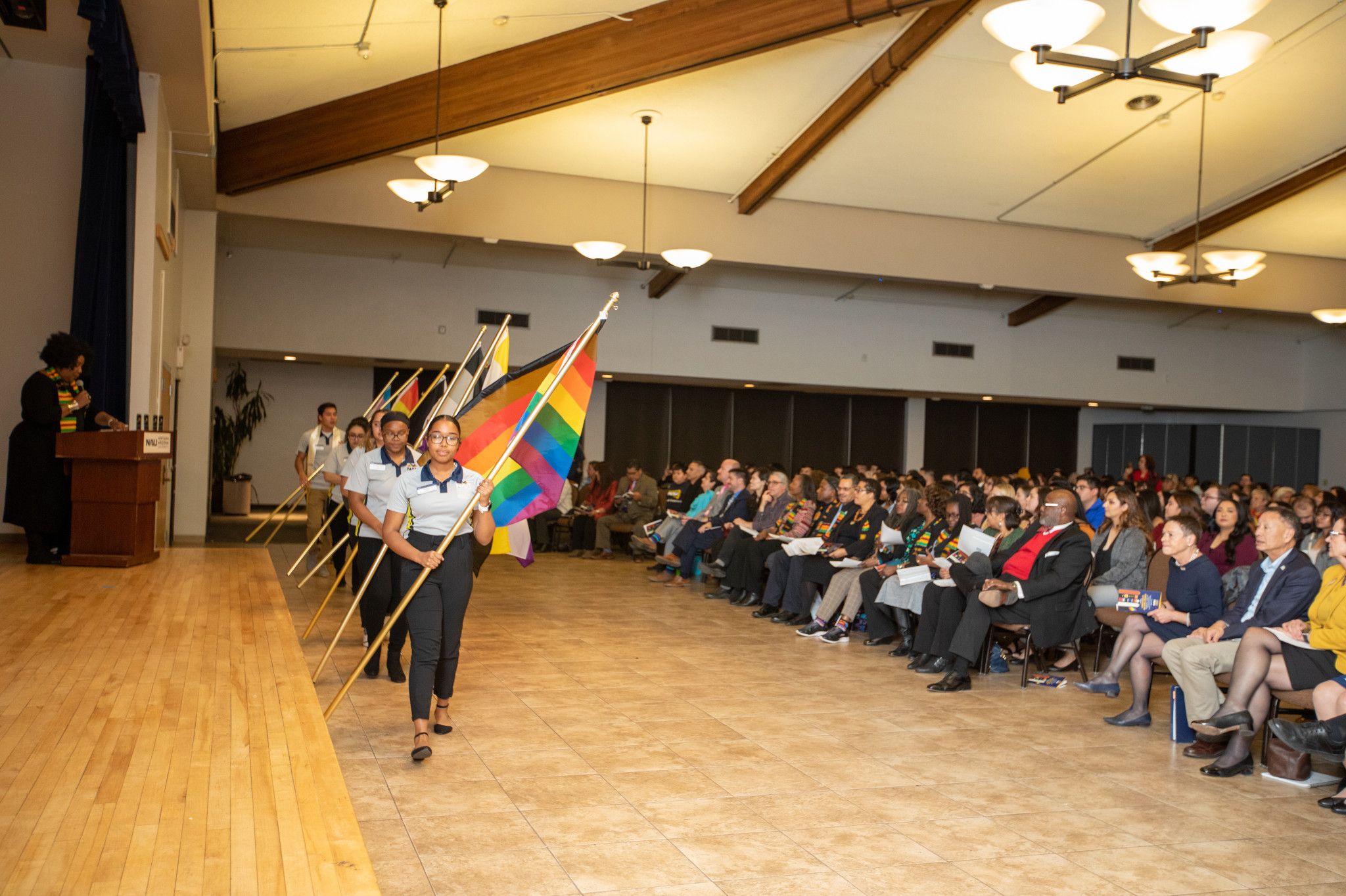 Lumberjacks of inclusion event hall featuring students holding pride flags.