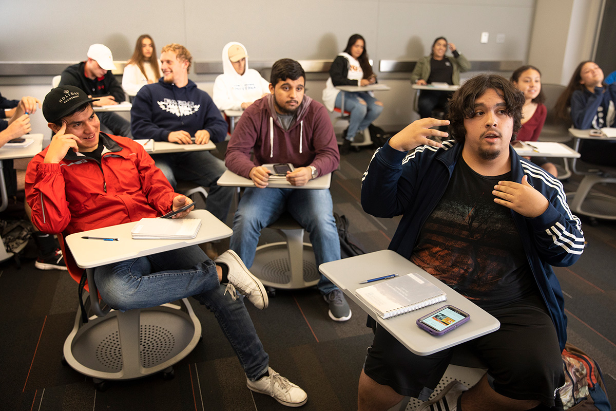 Students sit in a classroom and discuss.