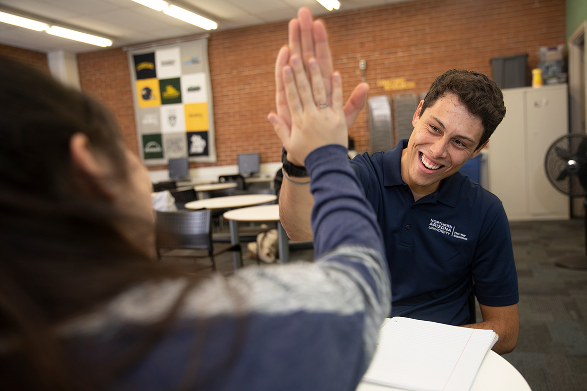 A mentor gives a student a high five.