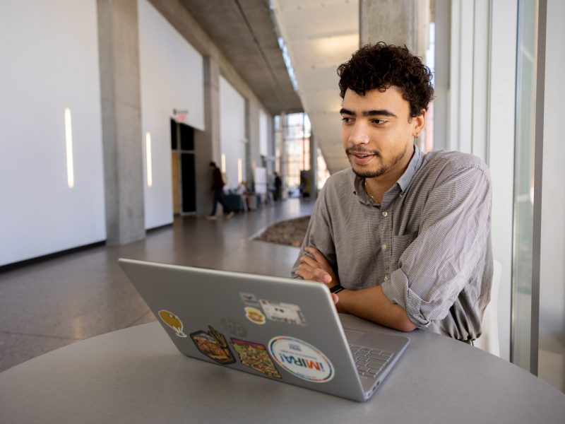 Student sitting at a table working on a computer