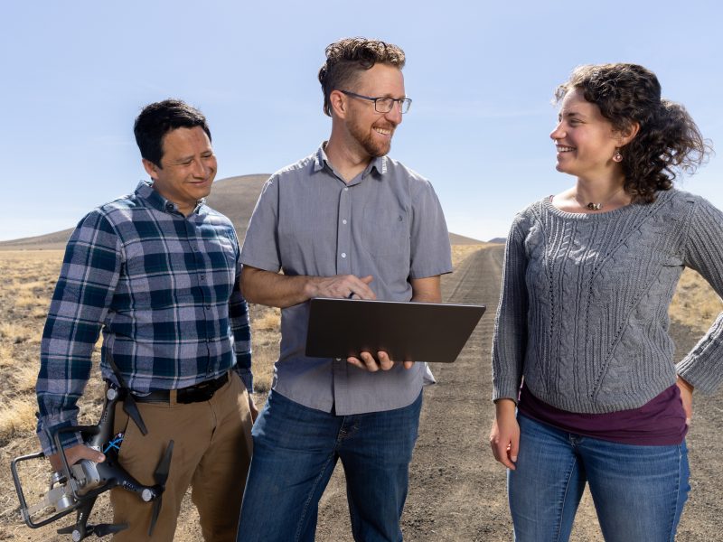 A photo of research students looking at a computer in the desert.