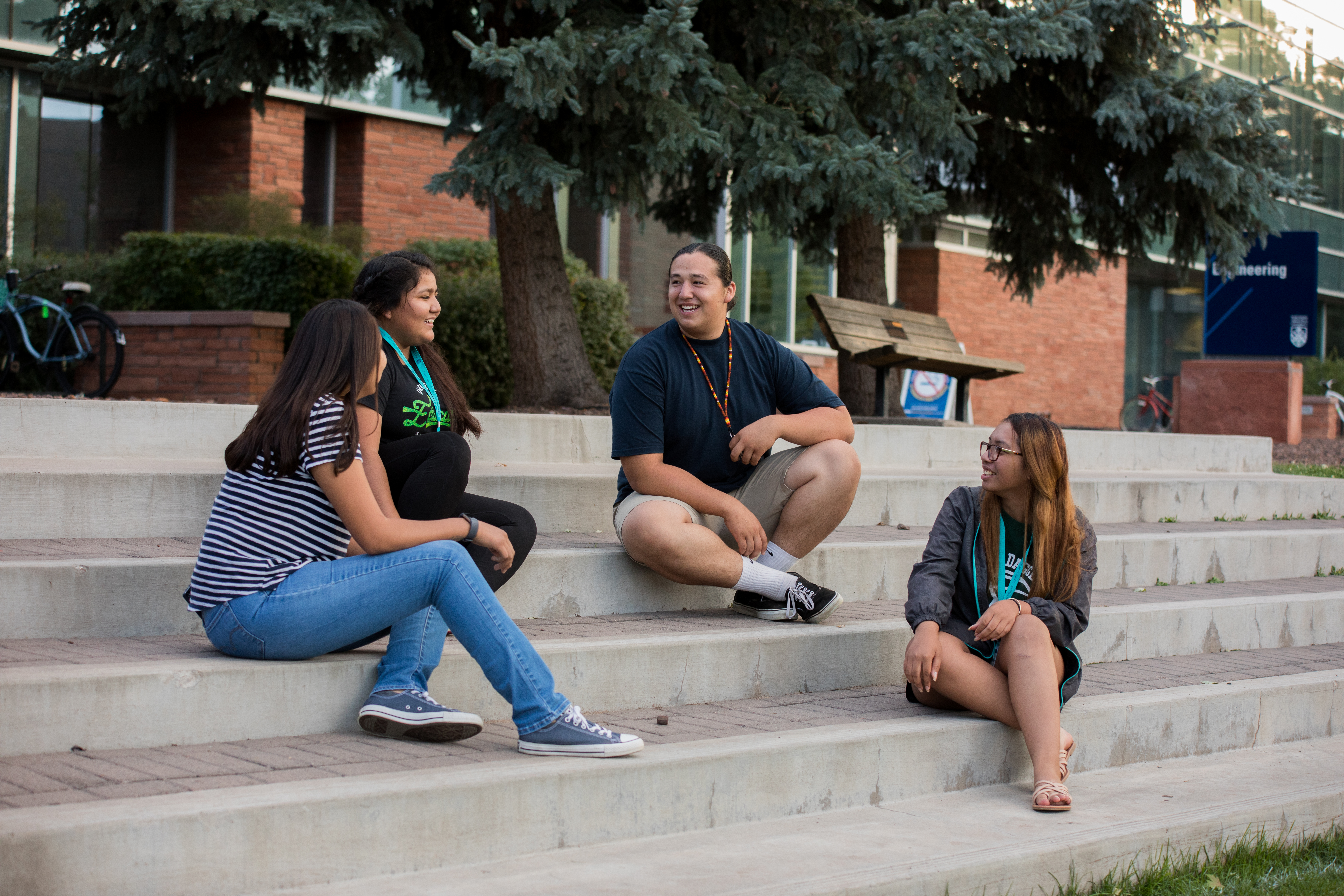 A group of students sitting on steps and talking.