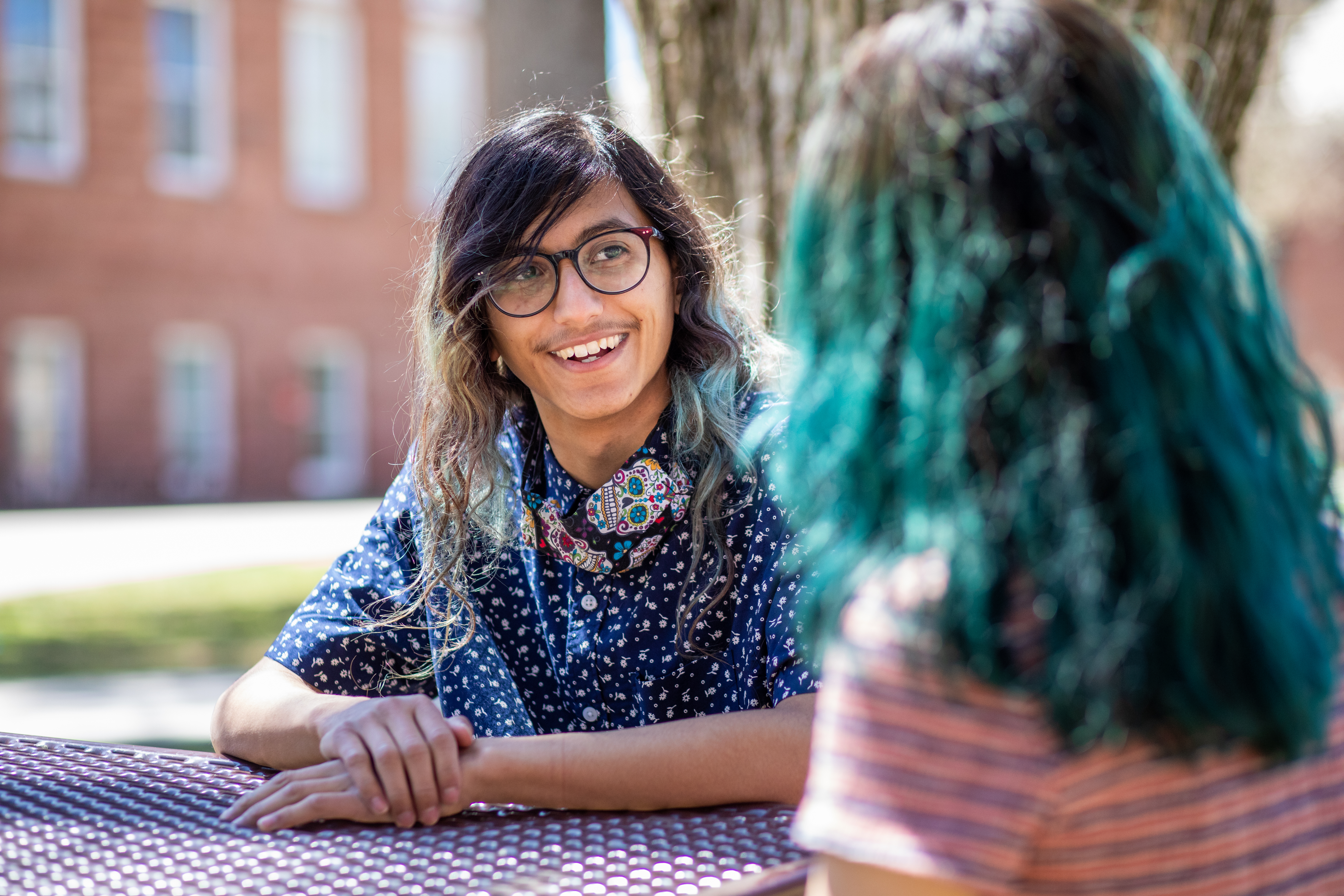 A photo of a student sitting outside and smiling.